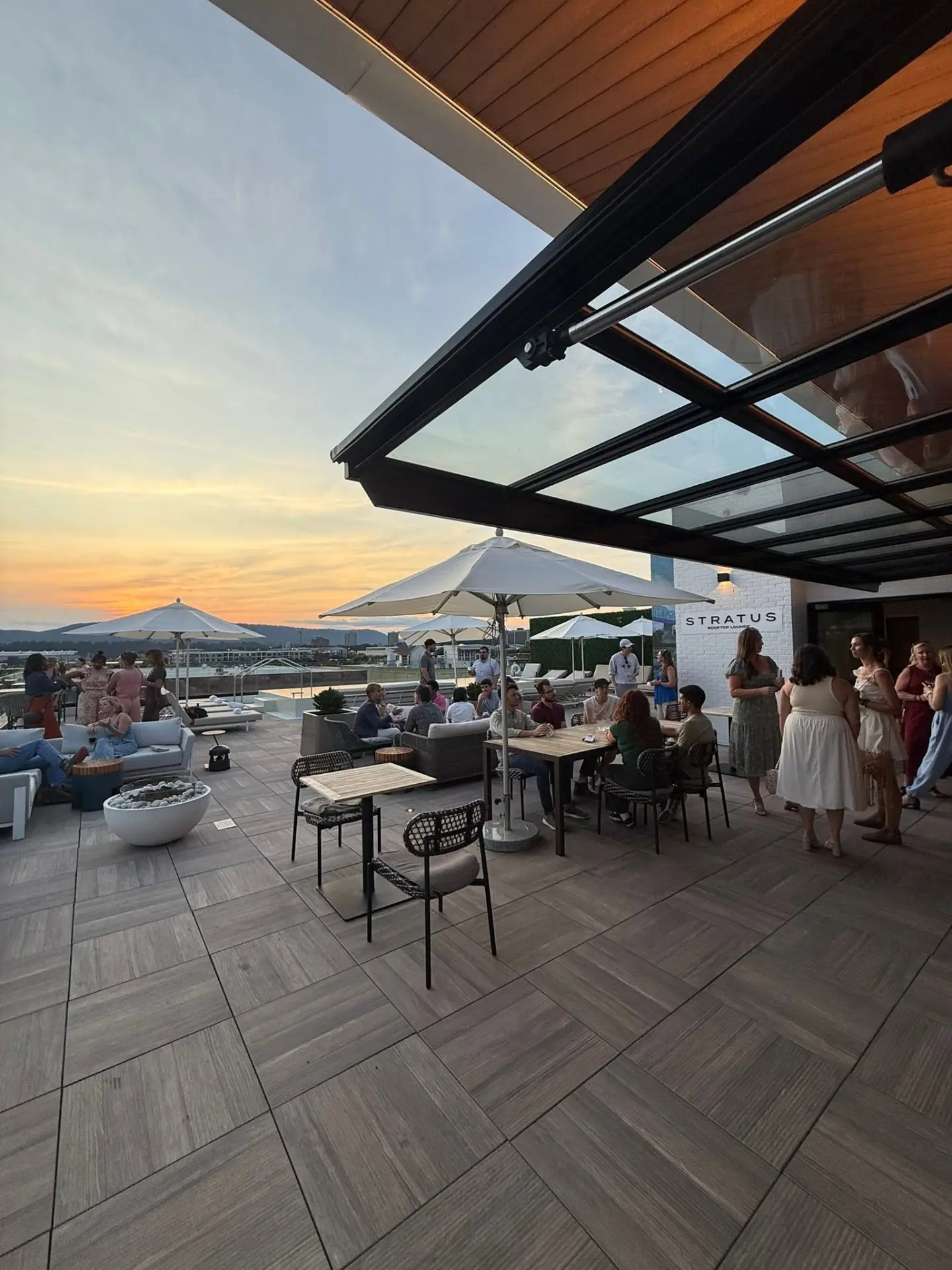Members gathered on a Chattanooga rooftop lounge at sunset